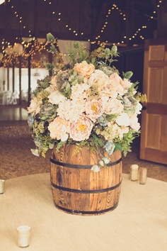 Rustic wedding accessories usually include wood, lace, and burlap. But the  unique use of a barrel here is a fabulous idea to incorporate into your decor! #rusticweddings #weddingdecor #flowers